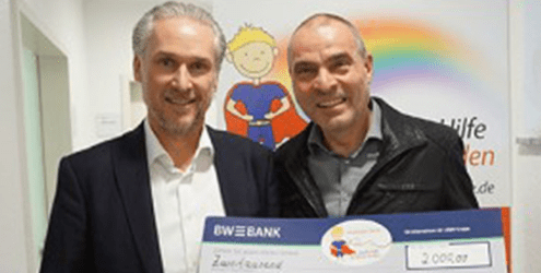 Herr Friedenauer bei der Spendenübergabe an Große Hilfe für kleine Helden